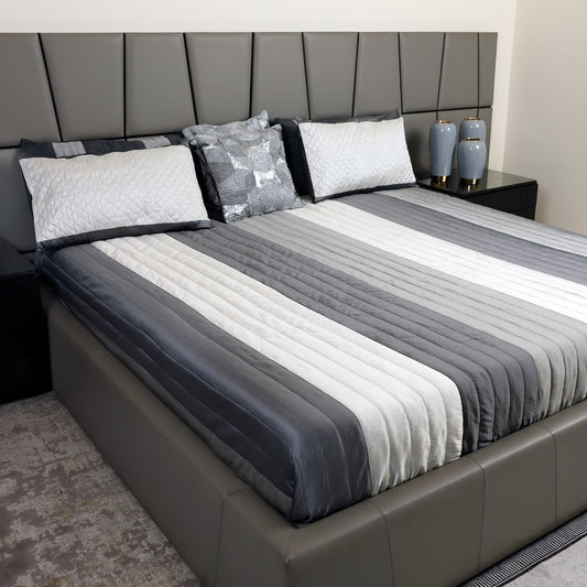 Bedroom with a bed featuring gray and white striped bedding and a dark headboard.